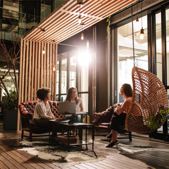 Three women discussing ideas in stylish office.