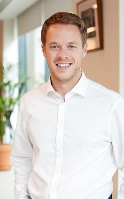 Smiling man in a white shirt indoors.